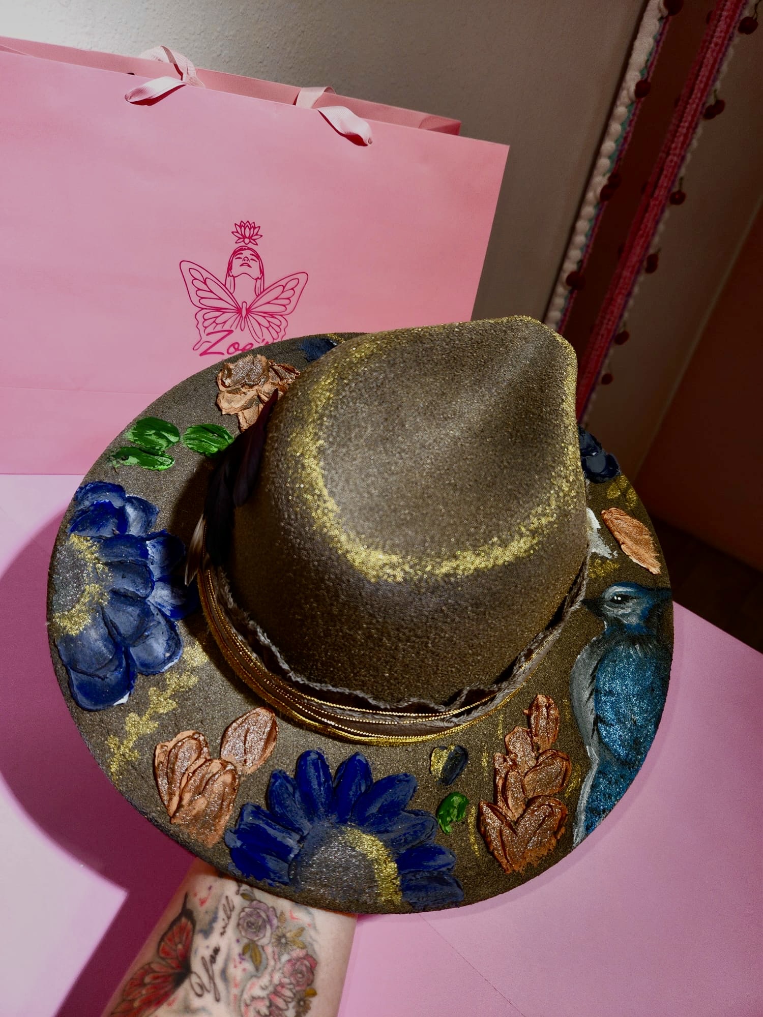 Sombrero oscuro con flores azules y rosas